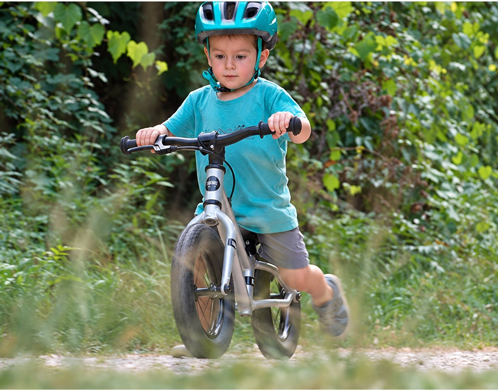 Child riding a TRAX BALANCE on a trail